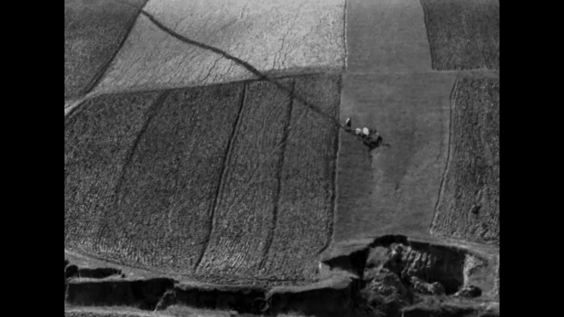 A black and white aerial shot of an agricultural landscape